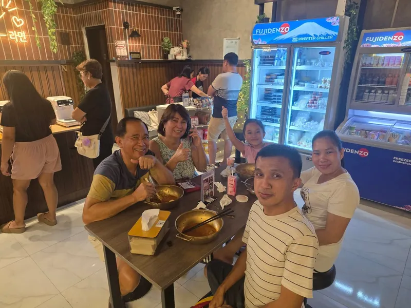 A family giving a thumbs up over hotpots at K-Stop