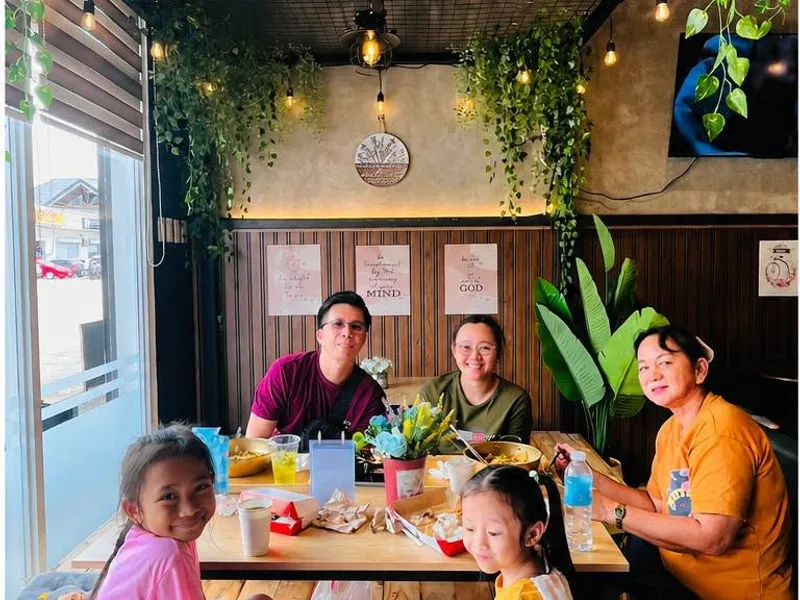 A family at the window-side floor table at K-Stop